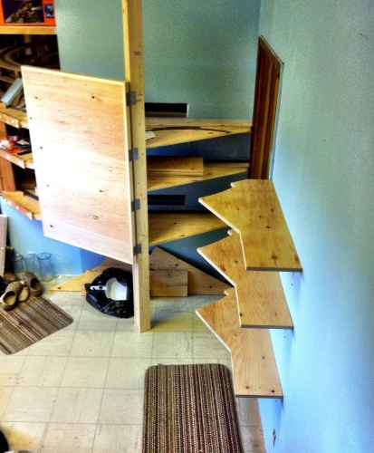 A view from the top of the stairs down to the new swinging door construction outside of Room 2.